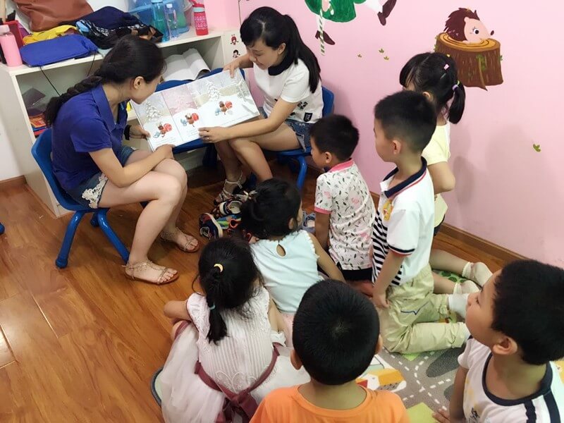 Katrina and Dutian share the book, “Toys Meet Snow” from CLP with a group of kids
