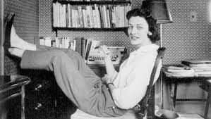 Anne Sexton sitting in front of a bookcase