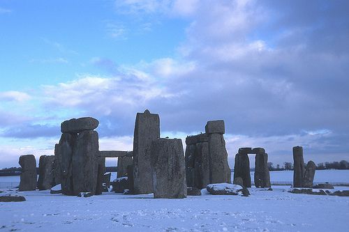 Stonehenge in winter, snow on the ground, the stones standing tall, with large lintel stones over the tops