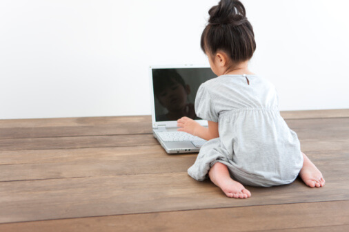 Girl using laptop, sitting on floor