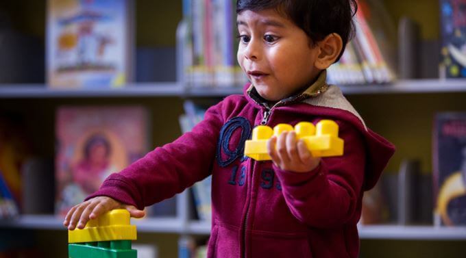 A young boy plays with blocks