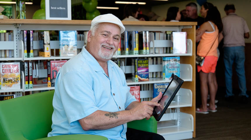 Person smiling with tablet in the adult reading area