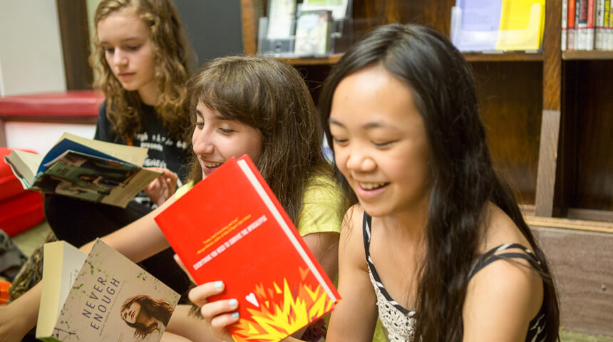 Teens smiling and looking at books