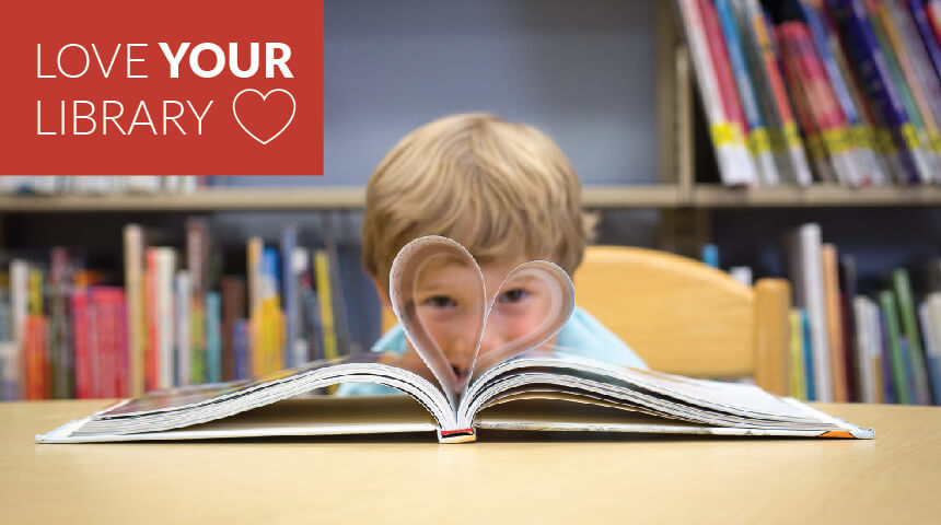 Child looking through a heart made from the pages of an open book