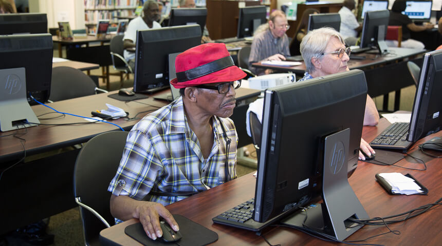 Adults attending a computer class working on an exercise.