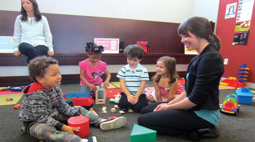 Librarian and children play with toys together during Family Playshop
