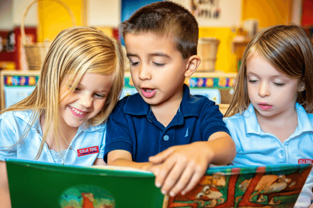 Three children read a picture book together