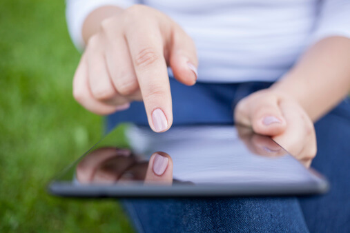 A patron uses their hands to navigate a tablet