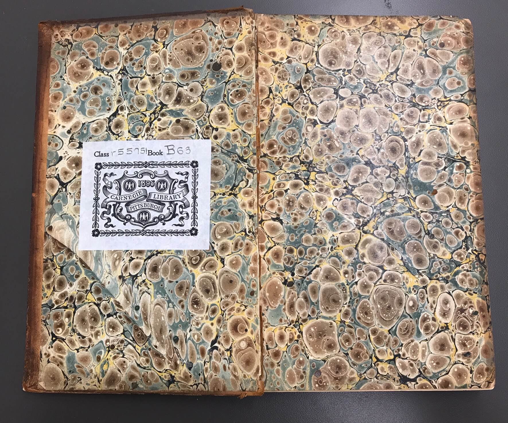 Example of a shell pattern end sheet with watery blue, earthy brown, and pale yellow made from historic bookbinding practices.