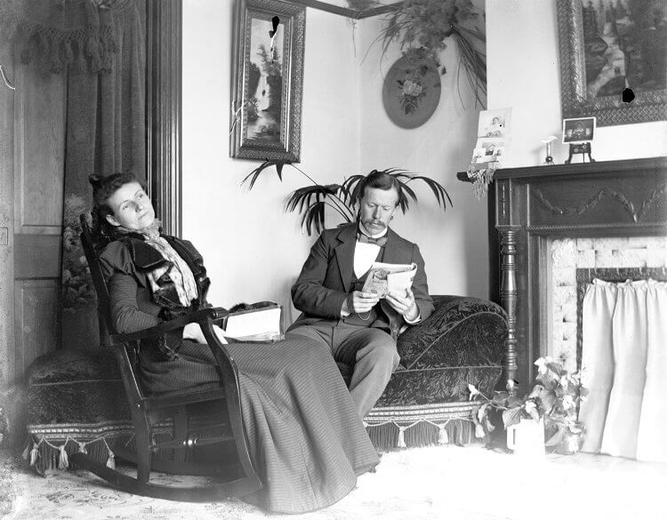 A black and white photo of a couple sitting in a parlor