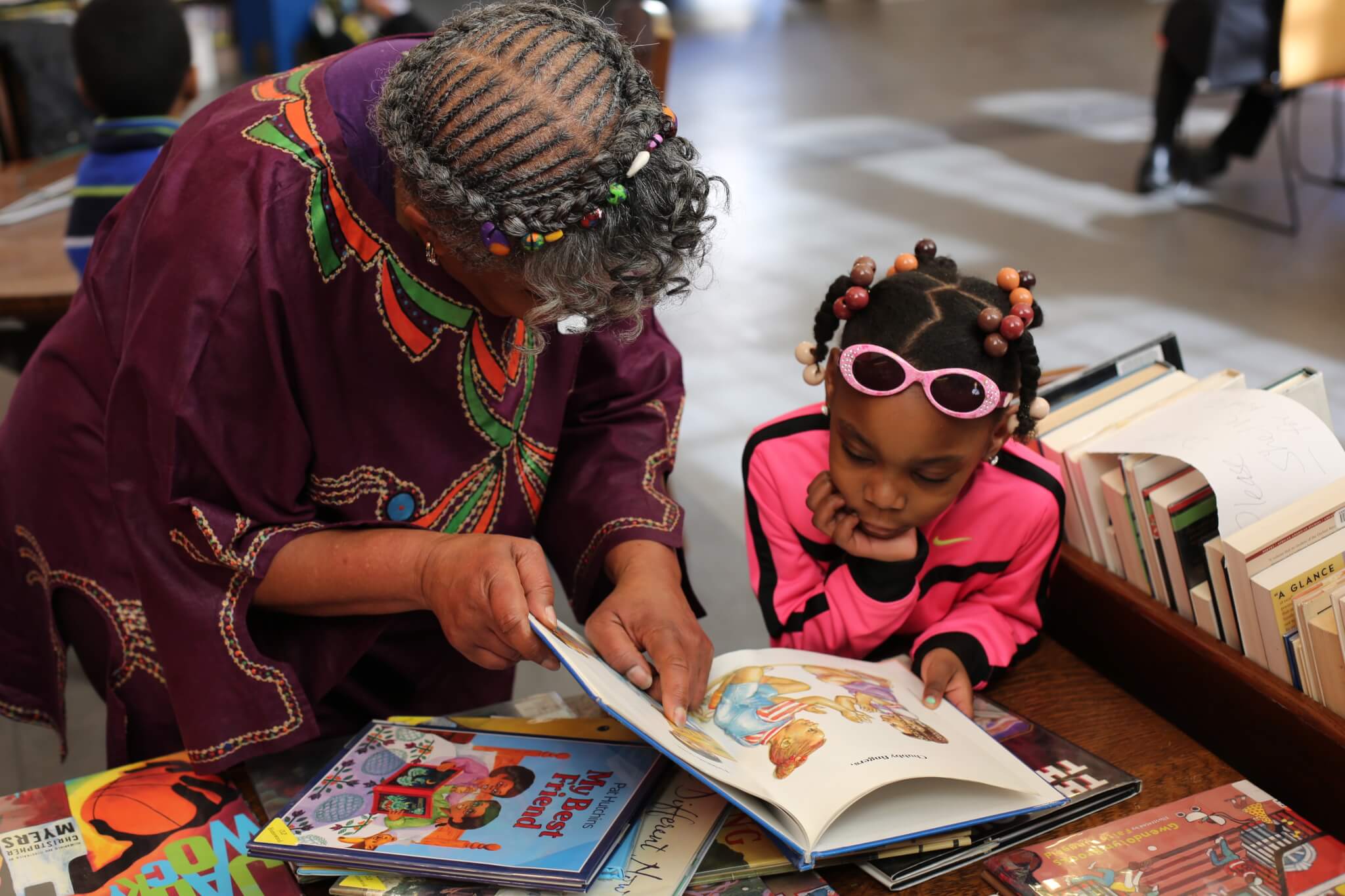Women looks at a book with a young girl