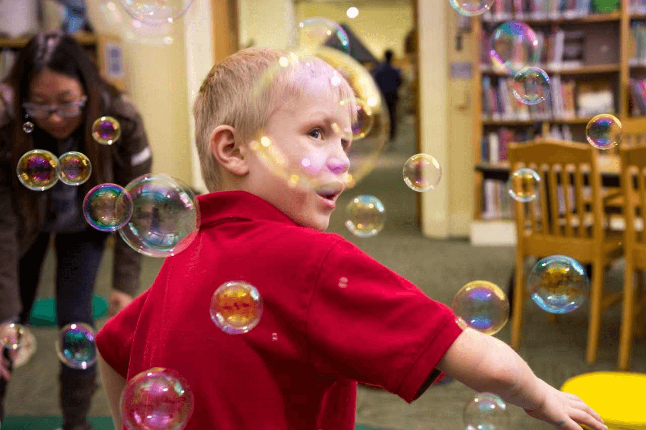 A child playing with bubbles in the children's room at CLP