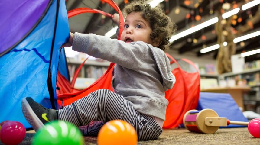 Image of a young child playing with a tunnel tube at Family Playshop.