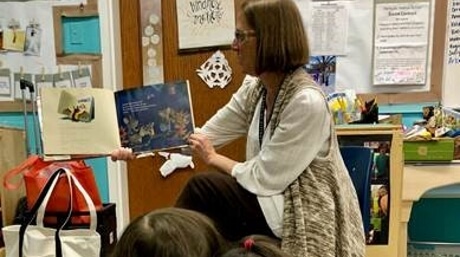 Librarian reads book to children in school