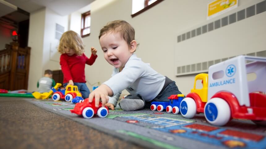 Two children play with cars and trucks