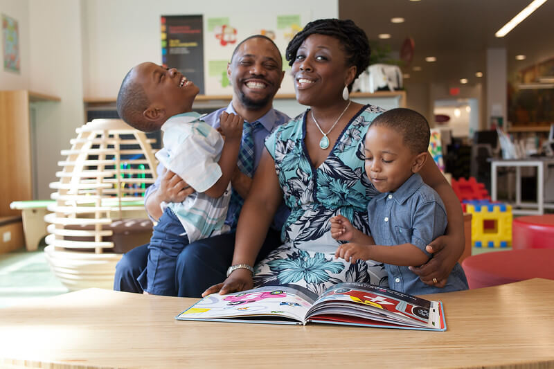 Family of four having fun in the library.