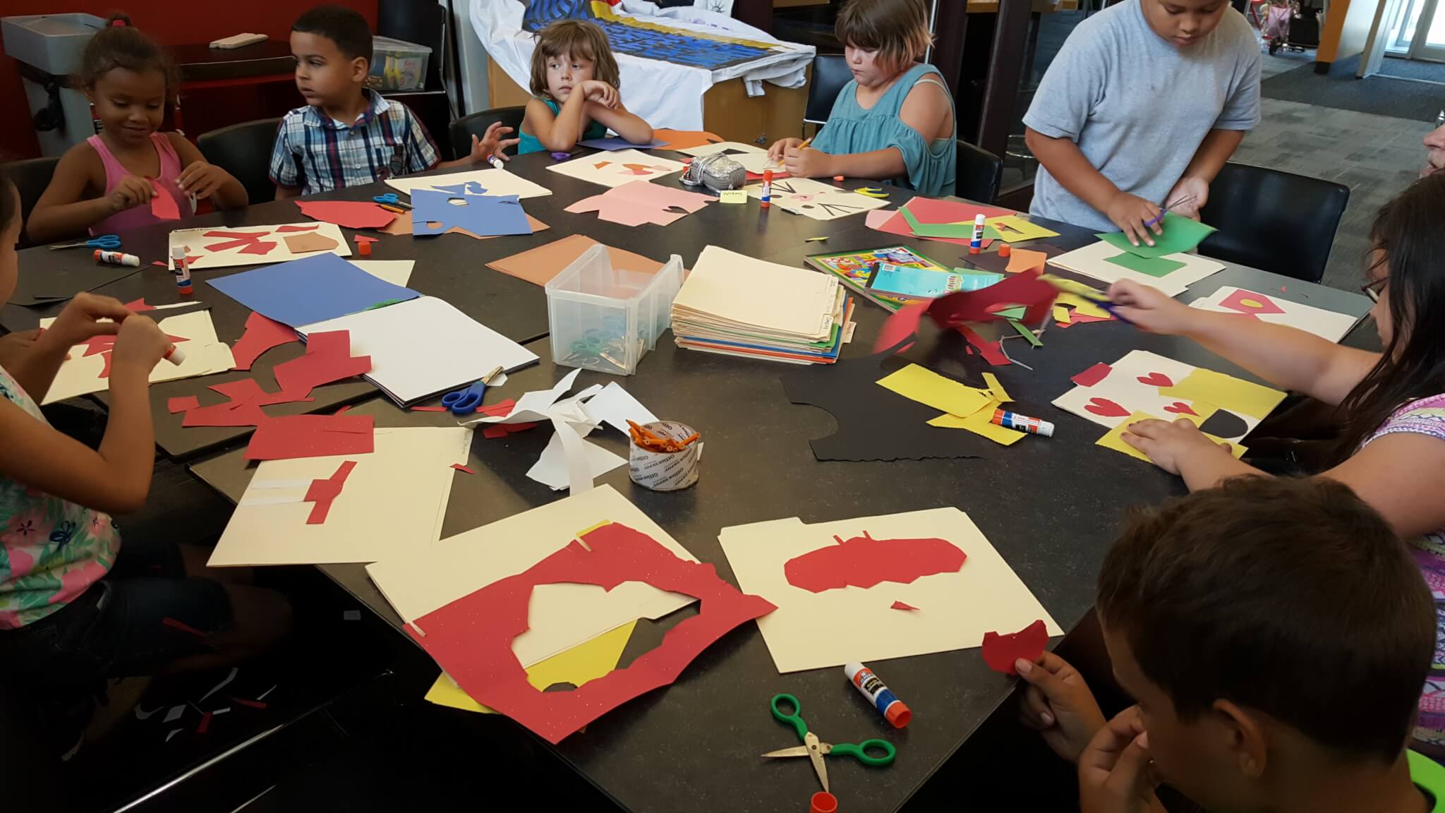nine children cut shapes out of paper