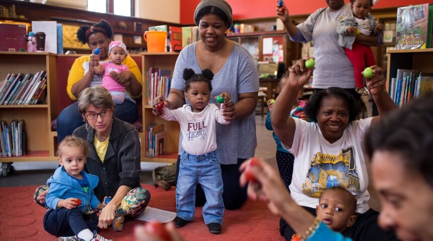 Caregivers and children use egg shakers in storytime