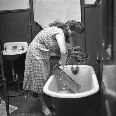 Mrs. Pagone hand washes her laundry in 1952.