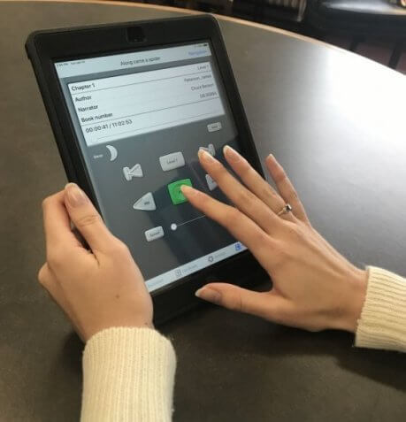 Woman's hands holding an iPad to use the BARD Mobile App. Her right pointer finger is pressing play.