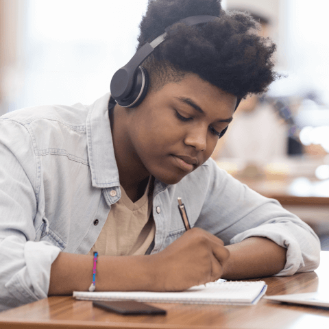 Teen listening to music while studying.