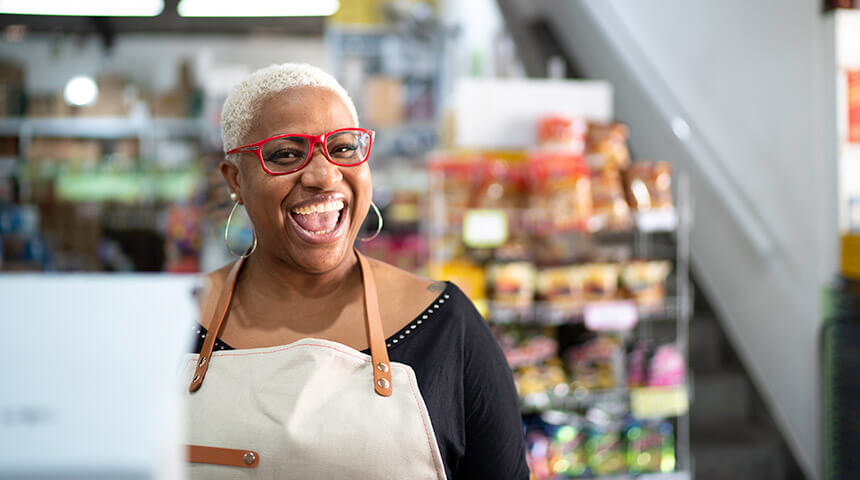 Smiling person wearing an apron in a store