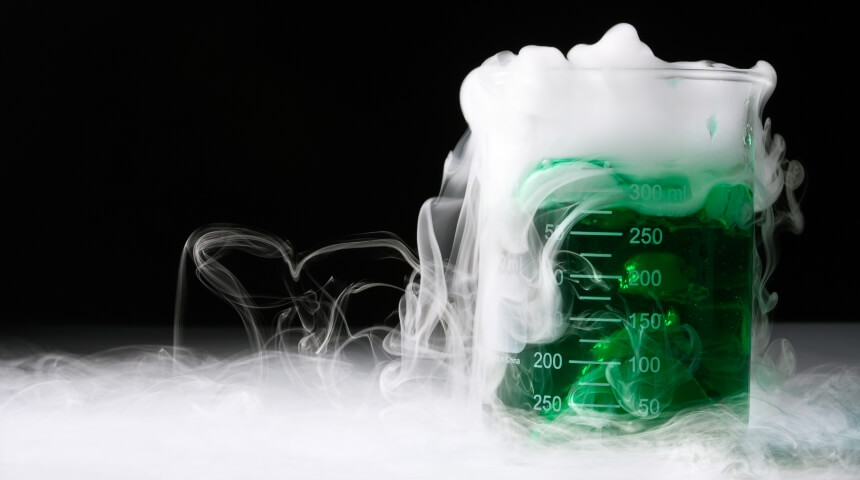 Photograph of a green, vaporous liquid in a chemistry beaker.