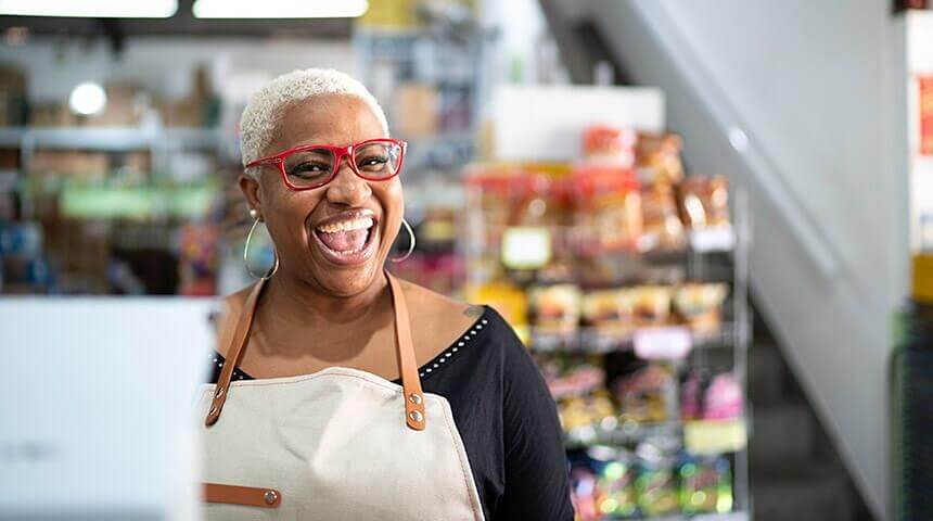 Smiling person wearing an apron in a store.