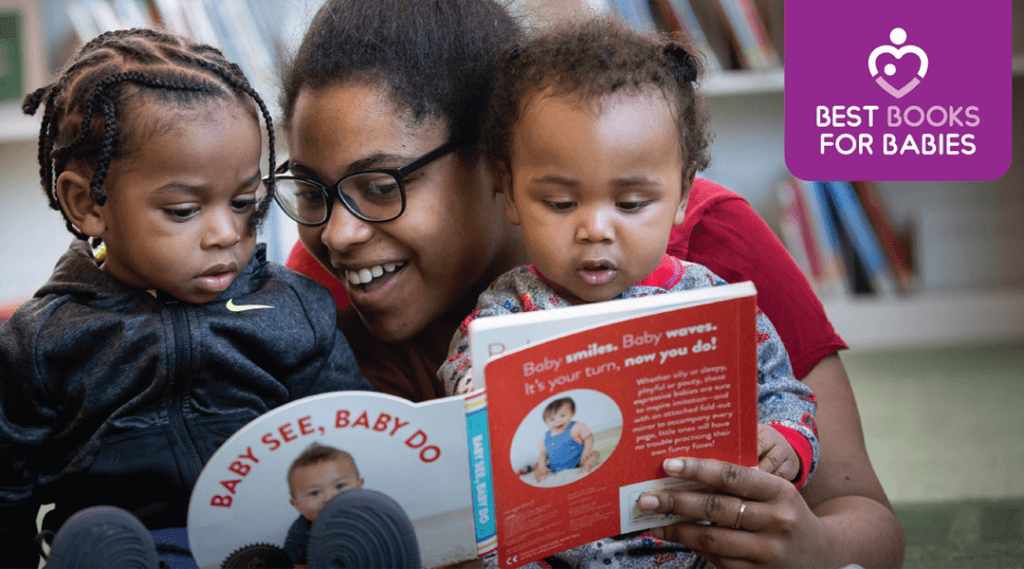 Caregiver and two toddlers reading a board book in the children's room.