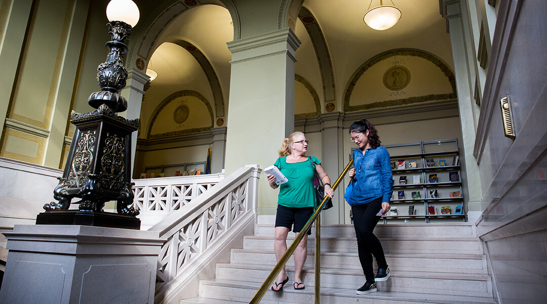 Two people walking down the stairs at CLP - Main.