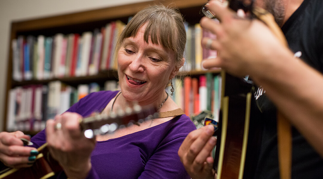 Two people playing the banjo at a library concert program.