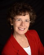 Author Karen Litzinger. Professional woman with glasses and a red blazer.