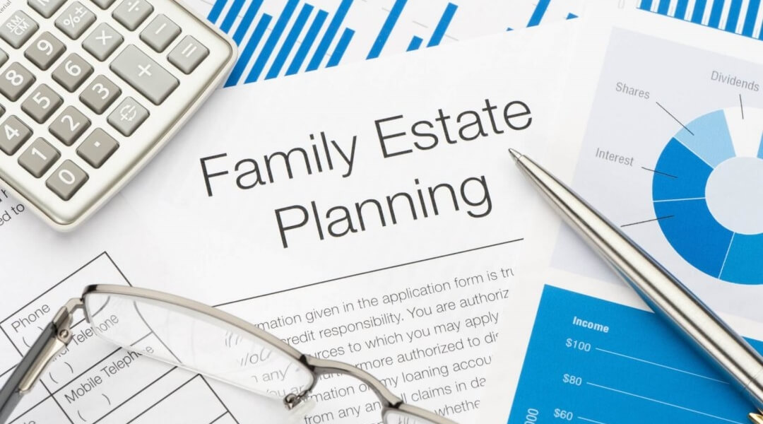 Calculator, pen and eyeglasses on top of estate planning forms.
