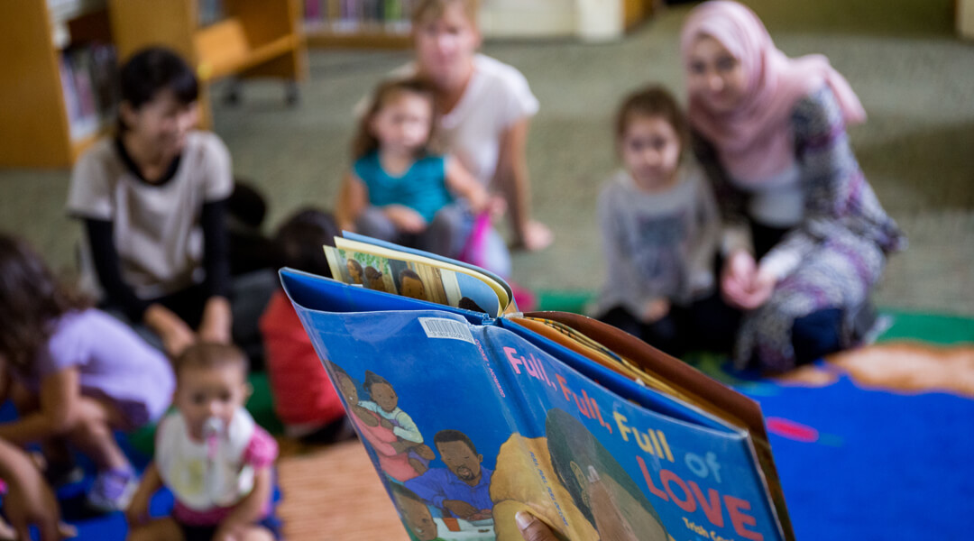 Picture book held up for storytime participants.