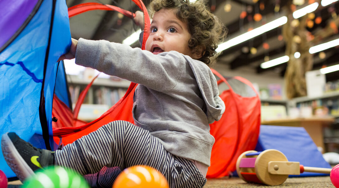 Toddler playing with ball pit in library