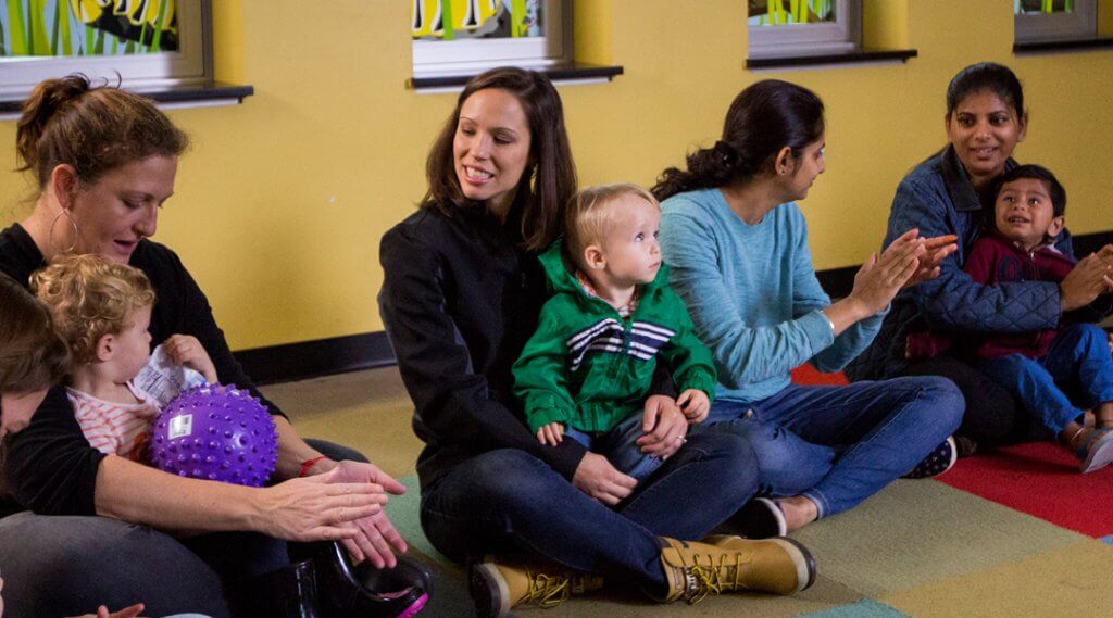 Caregivers with toddlers sitting in their laps for storytime