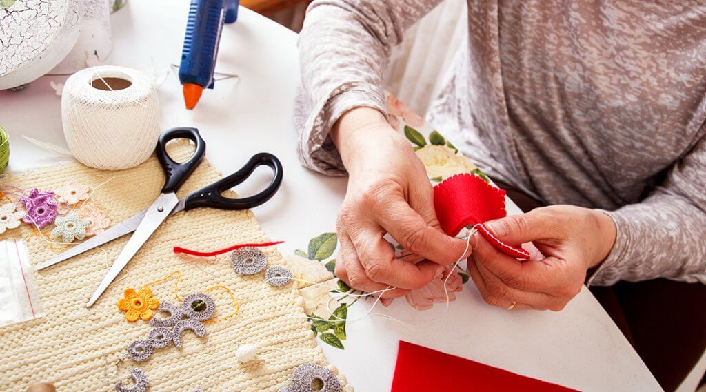 Woman sewing a heart shape ornament