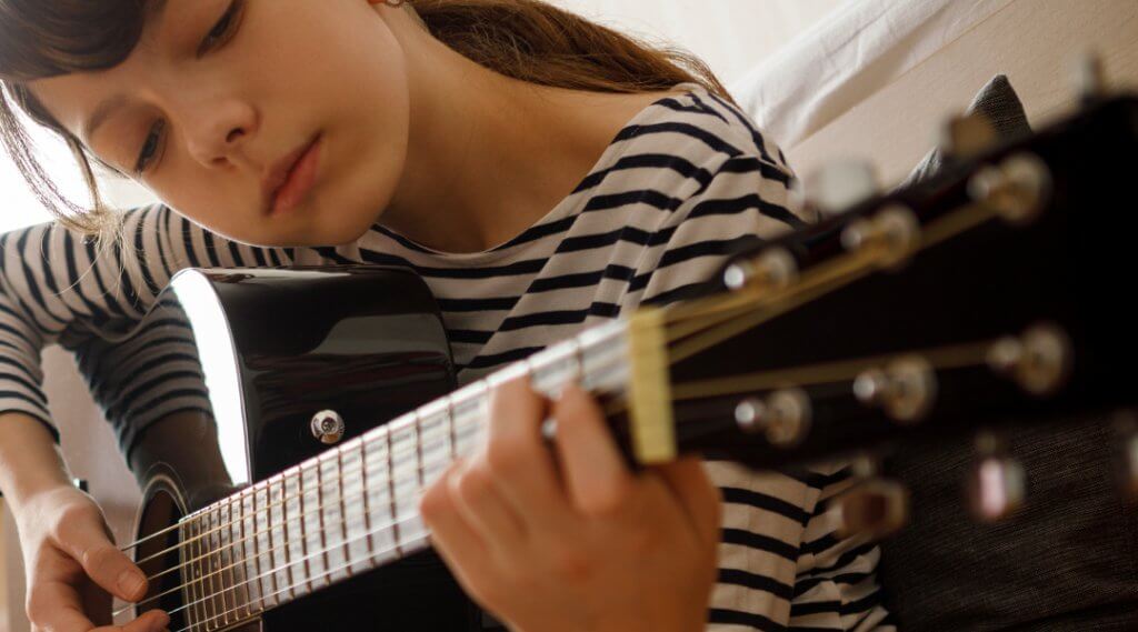 Teenager playing acoustic guitar