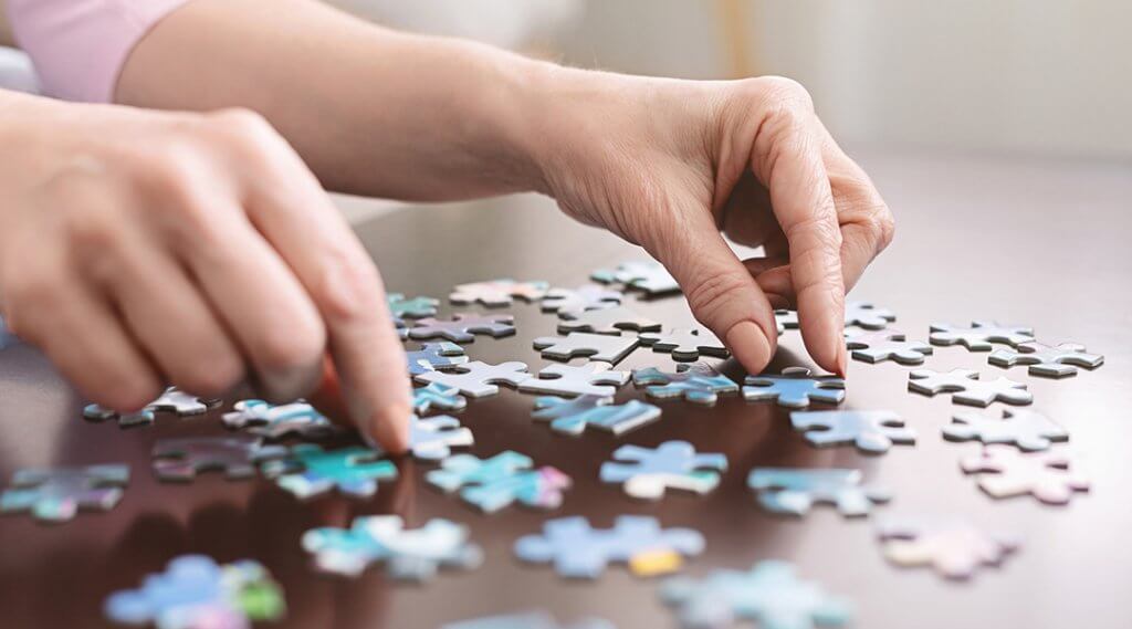 Hands doing jigsaw puzzle