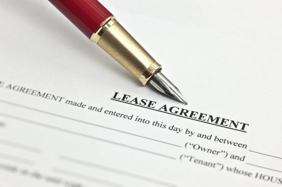 Photo of a contractual lease agreement with a ball point pen laying above the word Lease Agreement