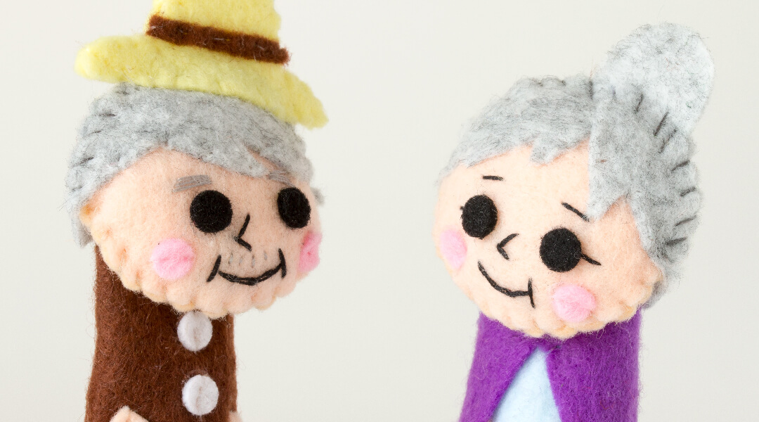 Close up of two felt elderly puppets.