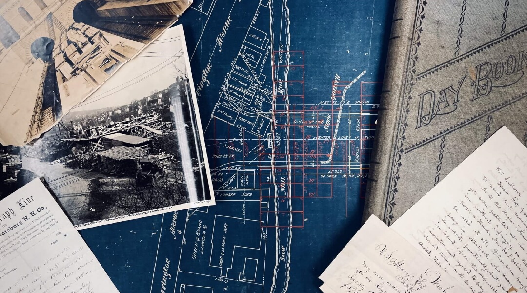 close up photo of archival records including blueprints, photos and letter
