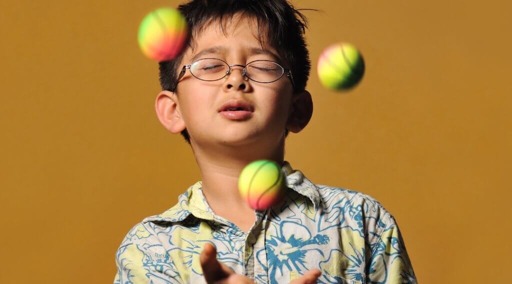 A child juggles three balls.