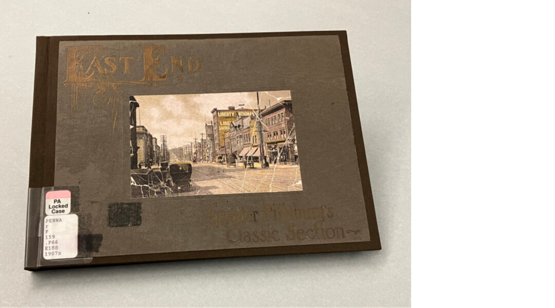 An image of a book with gold lettering, brown book cloth, and a color image of buildings in the middle. The title of the book is “East End Greater Pittsburg’s Classic Section” written in 1907.