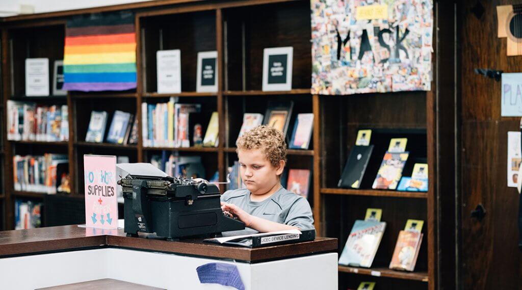 A child uses a typewriter in the library.