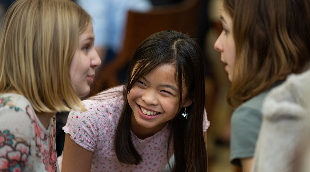 Three teens grouped together, smiling.