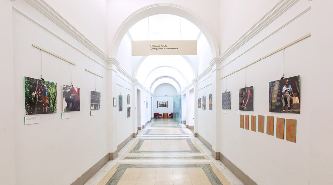 The Gallery at Main, a long white hallway with arching ceilings that has pieces of art hung on the walls.