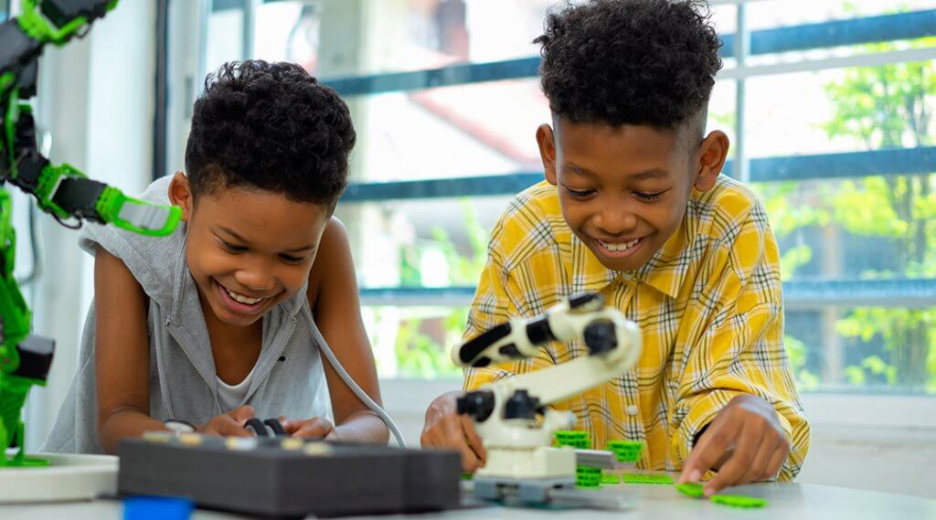 Two children play with robotics.
