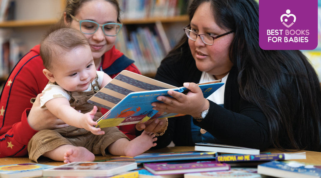 A librarian shares a board book with a baby and their caregiver.