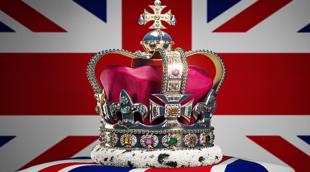An ornate red and gold crown in front of the Union Jack flag